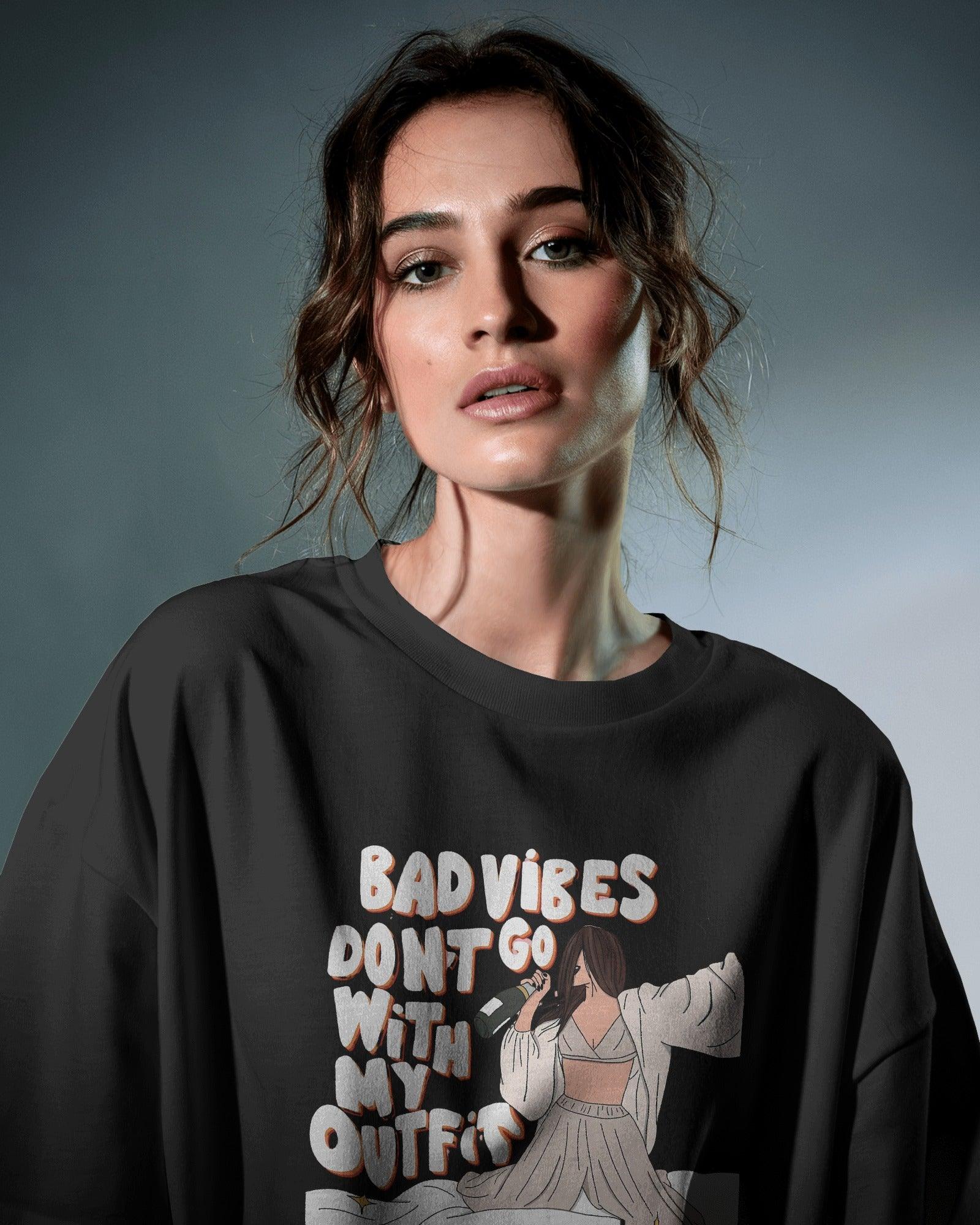 Oversized black t-shirt for women featuring the stylish quote "Bad Vibes Don’t Go with the Outfit" in bold typography. Crafted from premium cotton, this t-shirt offers a relaxed and comfortable fit. A perfect statement piece for casual and streetwear looks, adding a touch of confidence and positivity to any outfit.