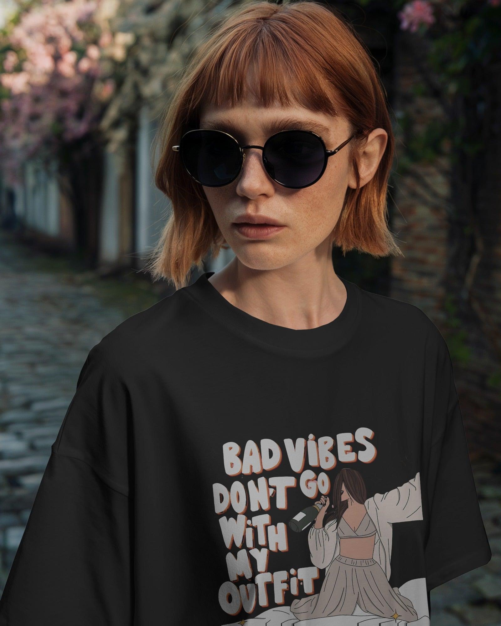 Oversized black t-shirt for women featuring the stylish quote "Bad Vibes Don’t Go with the Outfit" in bold typography. Crafted from premium cotton, this t-shirt offers a relaxed and comfortable fit. A perfect statement piece for casual and streetwear looks, adding a touch of confidence and positivity to any outfit.