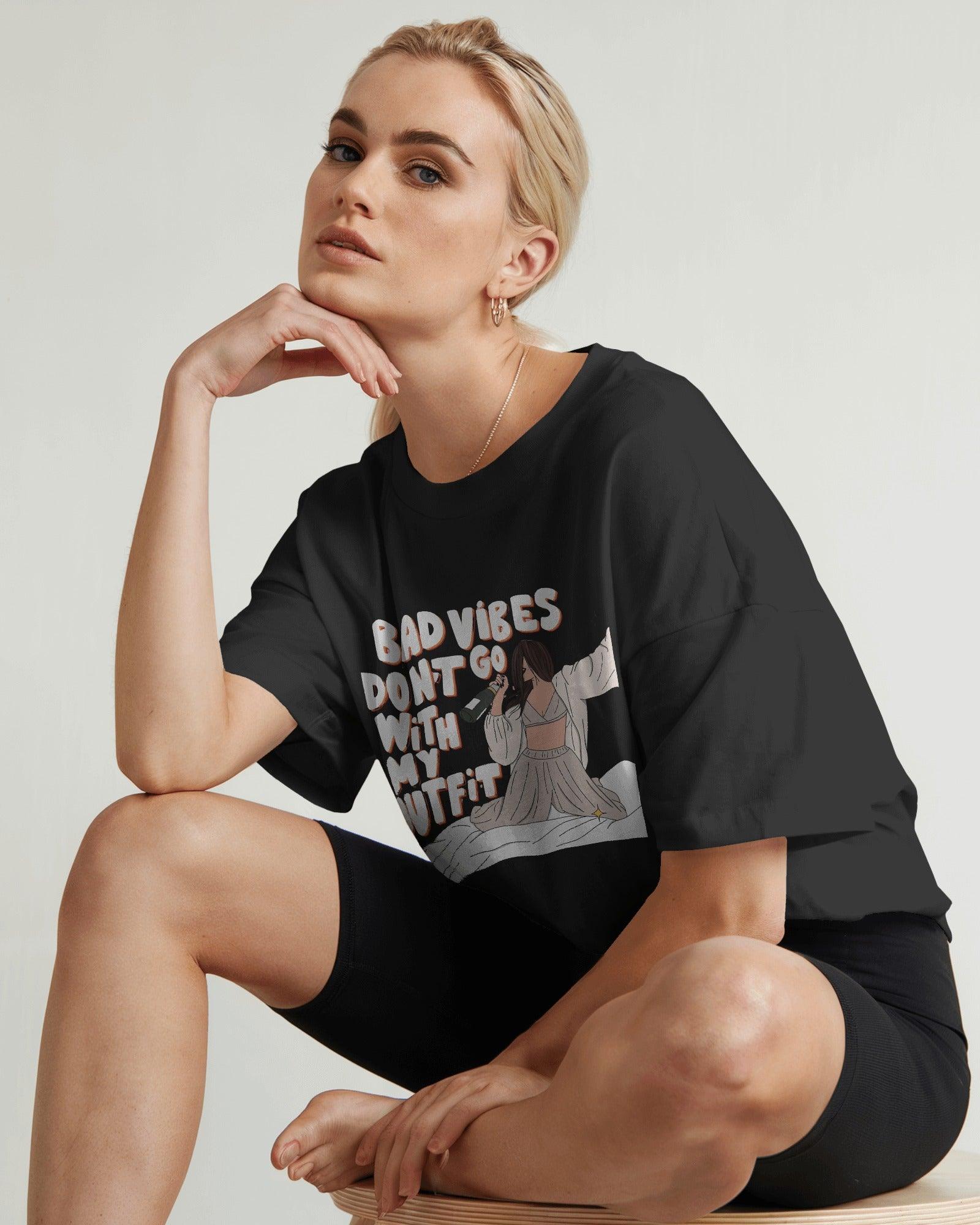Oversized black t-shirt for women featuring the stylish quote "Bad Vibes Don’t Go with the Outfit" in bold typography. Crafted from premium cotton, this t-shirt offers a relaxed and comfortable fit. A perfect statement piece for casual and streetwear looks, adding a touch of confidence and positivity to any outfit.