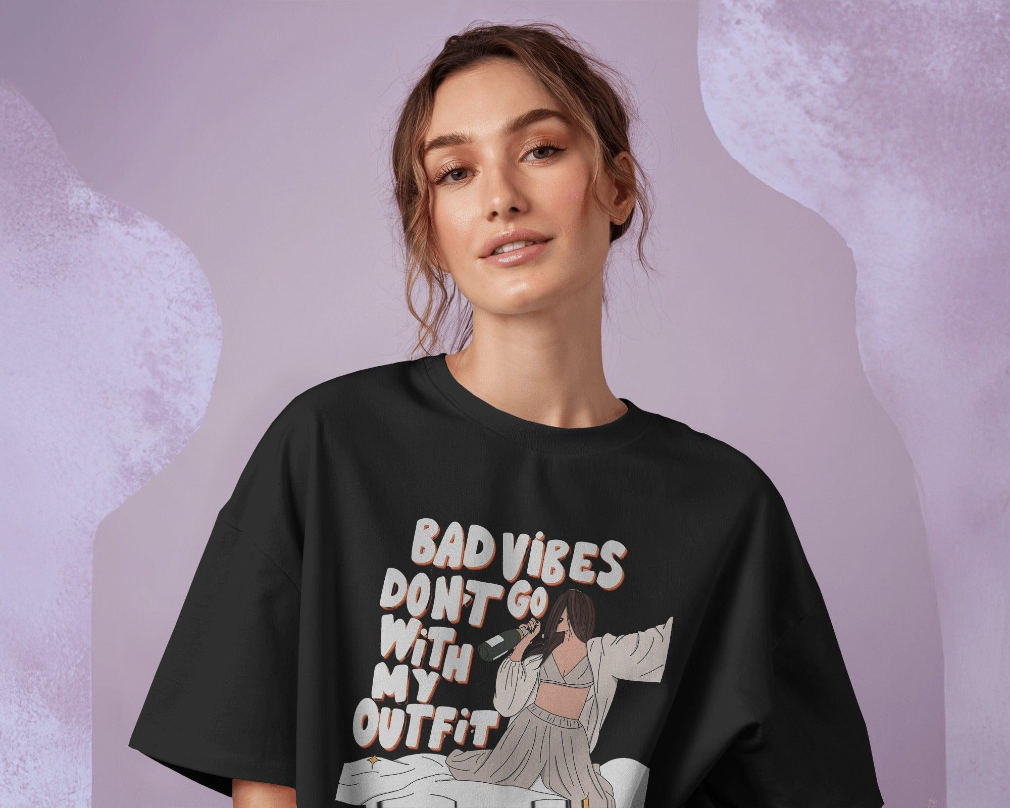 Oversized black t-shirt for women featuring the stylish quote "Bad Vibes Don’t Go with the Outfit" in bold typography. Crafted from premium cotton, this t-shirt offers a relaxed and comfortable fit. A perfect statement piece for casual and streetwear looks, adding a touch of confidence and positivity to any outfit.