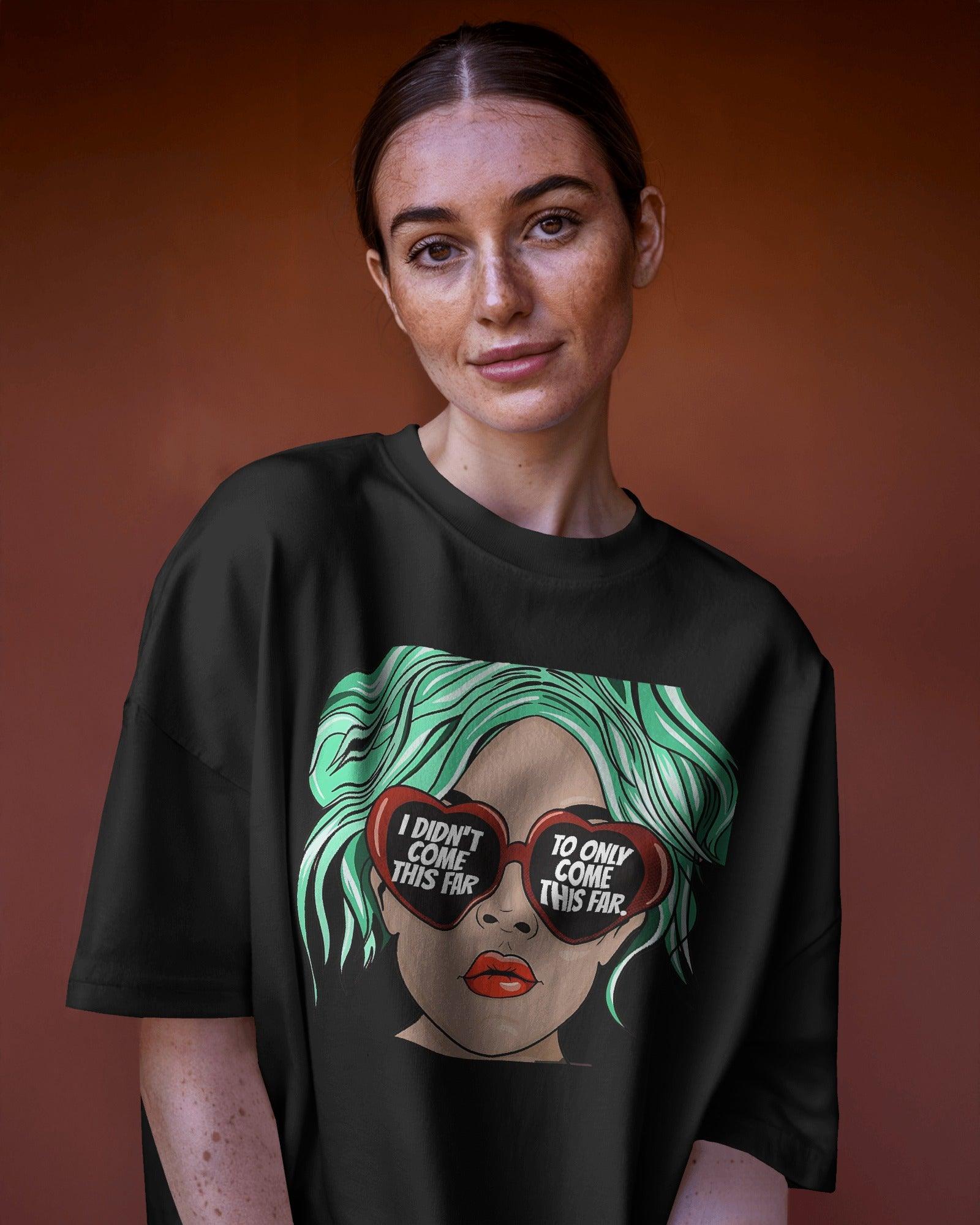Oversized black t-shirt for women featuring the motivational quote "I Didn’t Come This Far to Only Come This Far" in bold typography. Made from premium cotton, this t-shirt offers a relaxed and comfortable fit. Worn by a confident girl, the statement design adds an empowering touch to casual and streetwear outfits.