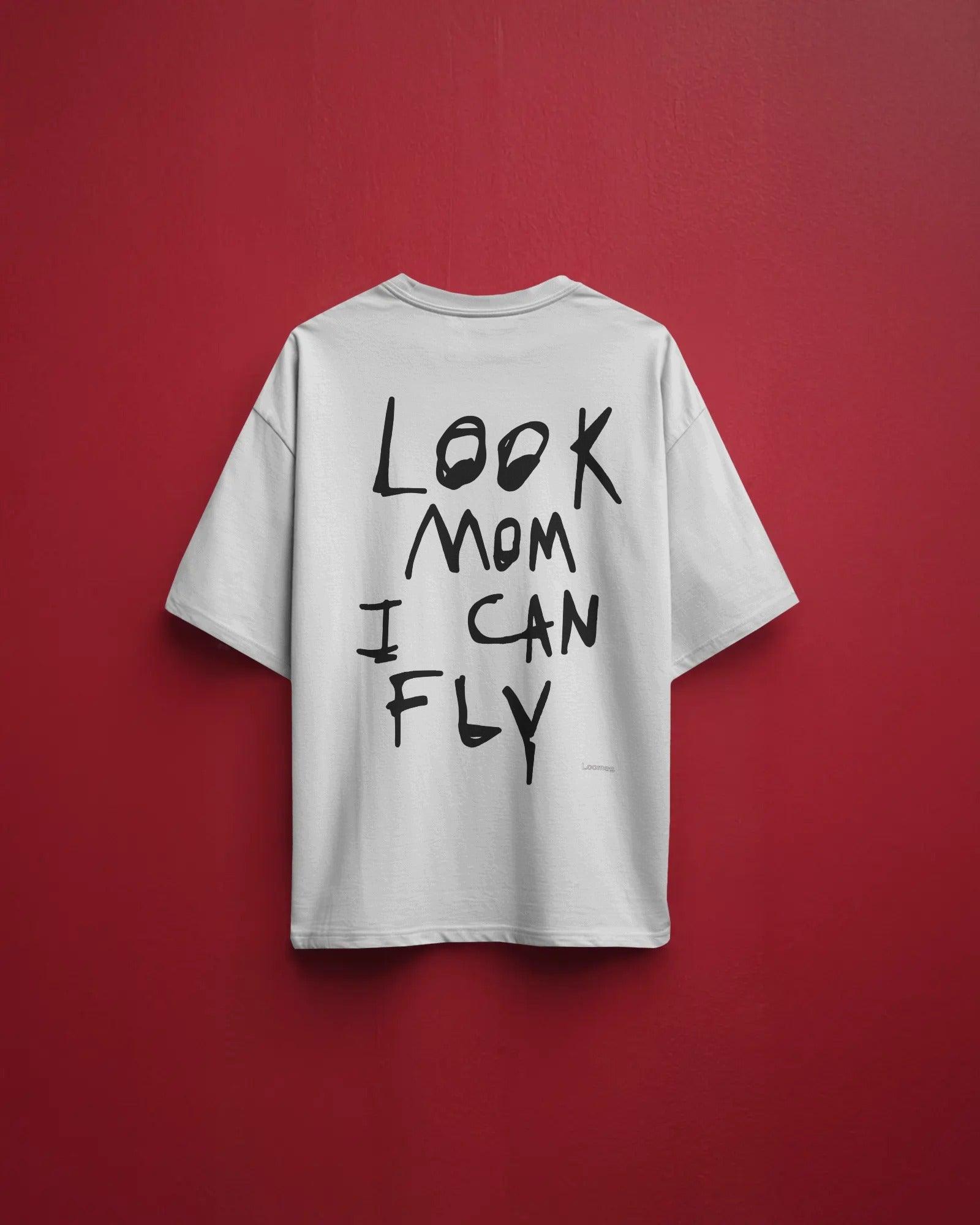 "White oversized t-shirt featuring 'Look Mom I Can Fly' Travis Scott-inspired print. Made from premium cotton, designed for a bold streetwear look.