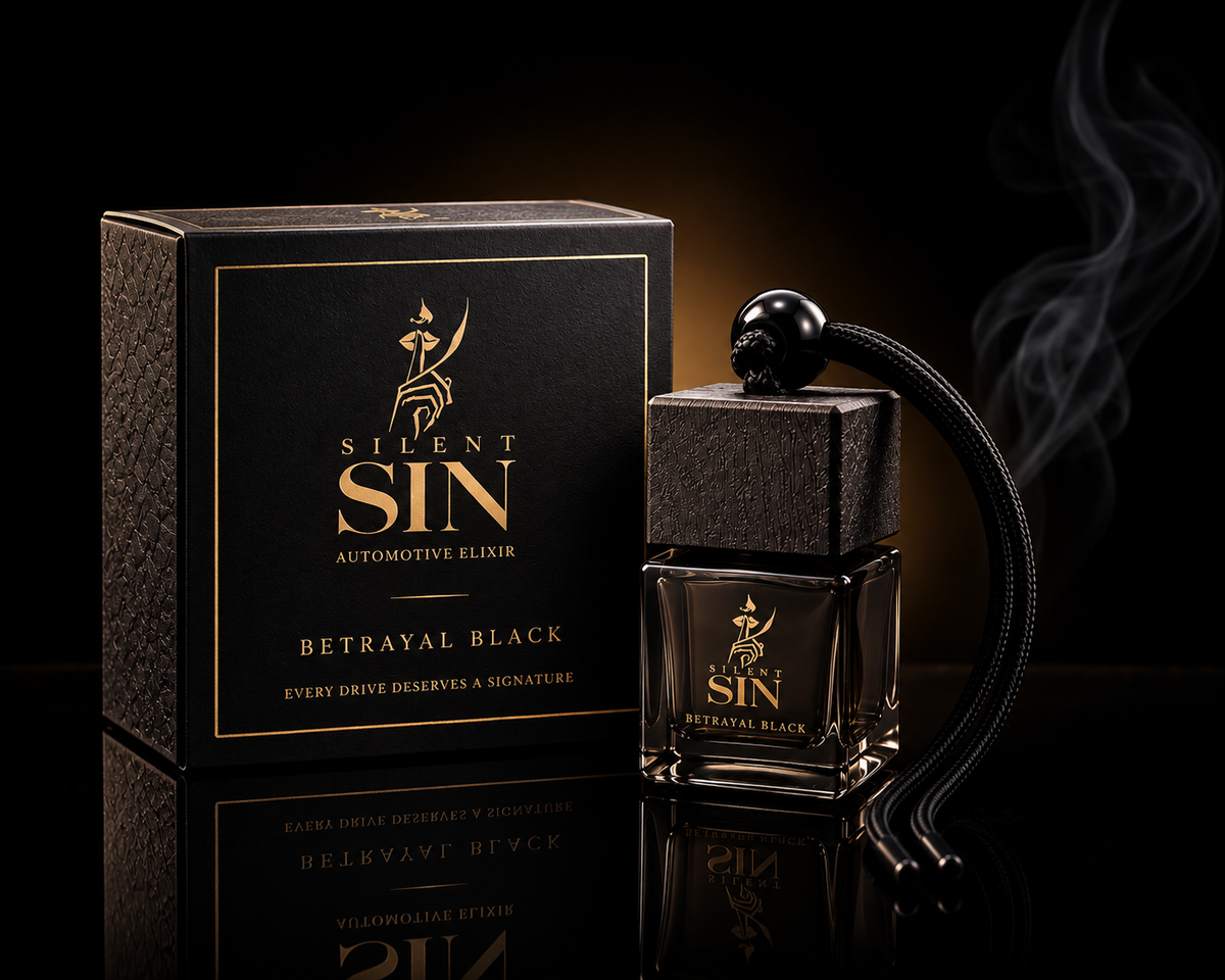 Silent Sin Betrayal Black automotive elixir perfume bottle with a black skull cap and black cord, displayed next to its textured black and gold packaging box on a reflective black surface.