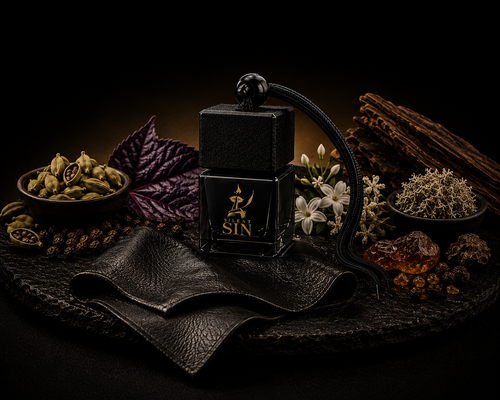A black rectangular perfume bottle labeled 'SILENT SIN' with a black leather neck strap, styled on a dark stone surface with leather, spices, flowers, and dried botanicals against a black background. Silent Sin Automotive Elixir Car Fragrance