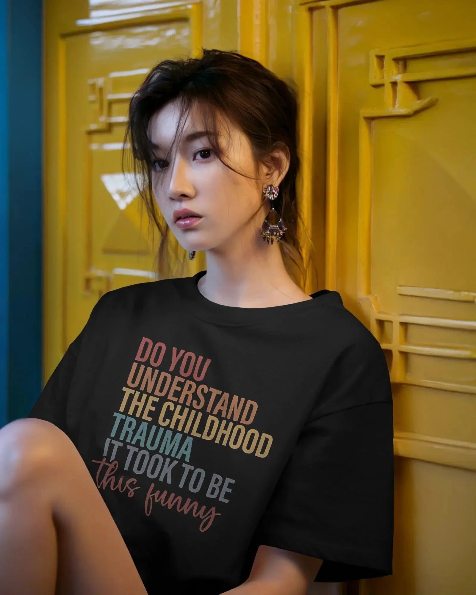 Oversized black t-shirt with bold white text that reads, ‘Do you understand the childhood trauma it took to be this funny?’ A witty and relatable statement piece, crafted from premium cotton for comfort and effortless streetwear style.