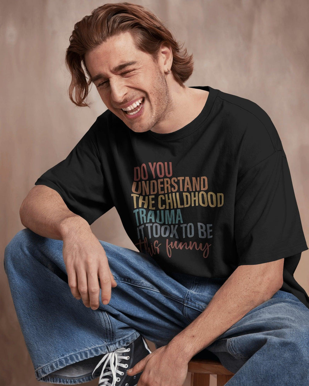 Oversized black t-shirt with bold white text that reads, ‘Do you understand the childhood trauma it took to be this funny?’ A witty and relatable statement piece, crafted from premium cotton for comfort and effortless streetwear style.