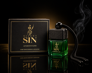 A green glass bottle labeled 'SILENT SIN AUTOMOTIVE ELIXIR' stands beside its black box with gold lettering on a dark reflective surface. A black hanging cord with a round end and wisps of smoke drift around the bottle against a black background. Oud Car perfume