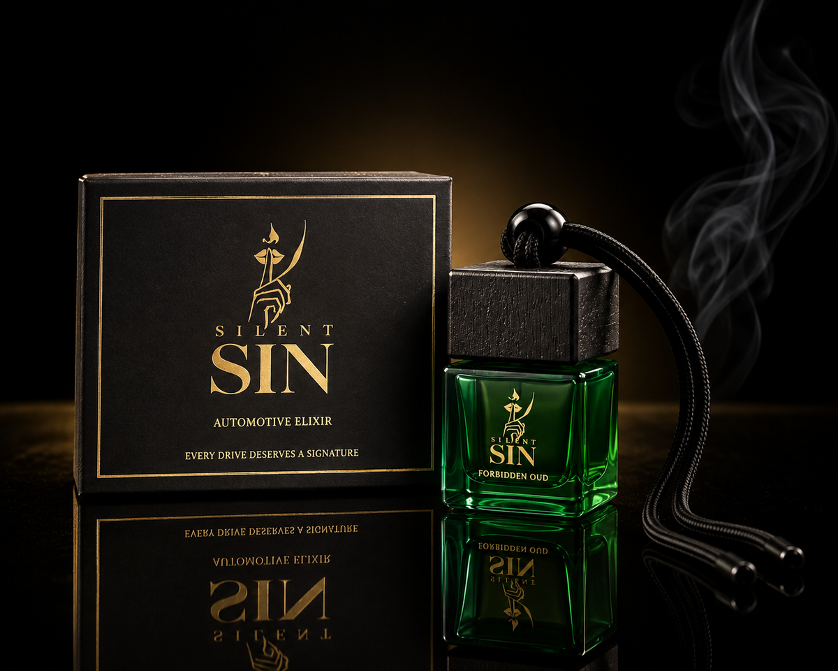 A green glass bottle labeled 'SILENT SIN AUTOMOTIVE ELIXIR' stands beside its black box with gold lettering on a dark reflective surface. A black hanging cord with a round end and wisps of smoke drift around the bottle against a black background. Oud Car perfume