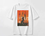 A white short-sleeve crewneck t-shirt featuring a large rectangular graphic print on the front with the text 'FRED AGAIN' in orange and a dark photo of Fred Again holding a mike.