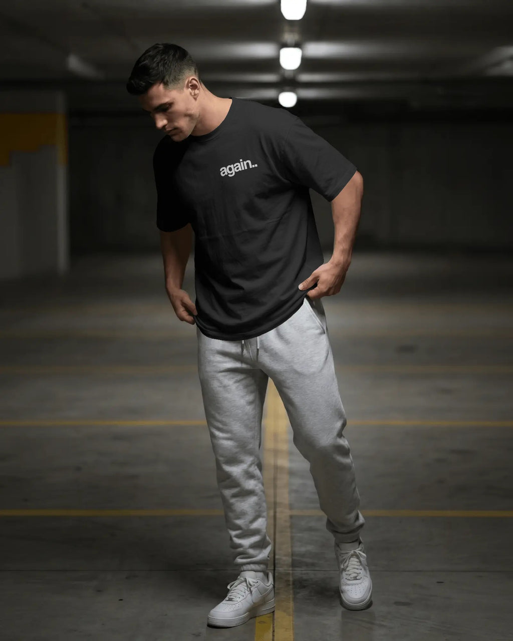Man wearing a black t-shirt with a logo and light gray pants in an indoor setting Fred Again.. Tshirt India