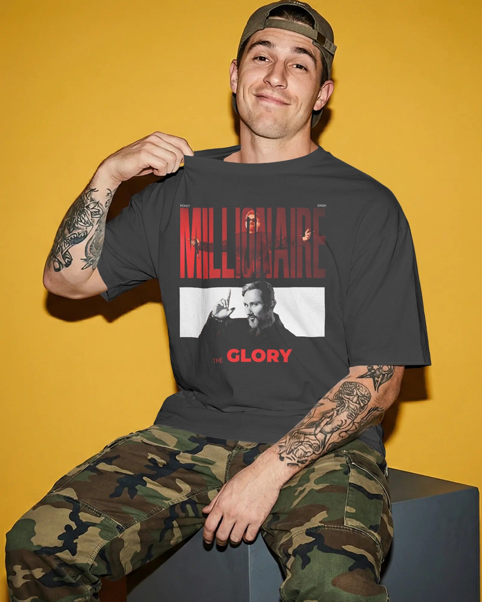 Man wearing a t-shirt with graphic design and text, sitting against a yellow background