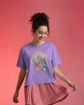 Woman wearing a Lavender Labubu t-shirt with cartoon characters and a rainbow on a pink background