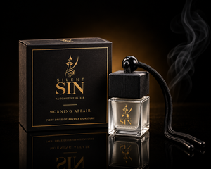 Silent Sin Morning Affair automotive elixir bottle and packaging box on a reflective black surface with a smoky background. Coffee Car Fragrance Silent Sin Automotive Elixir Car Fragrance