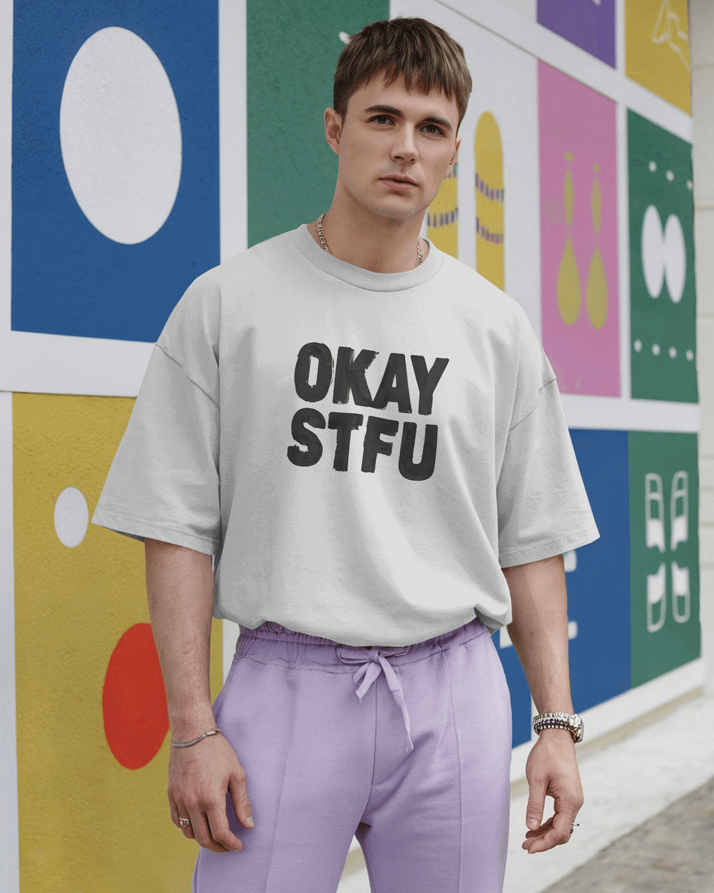 Person wearing a white Nitorious Atelier AP Dhillon concert t-shirt with 'OKAY STFU' text against a light background