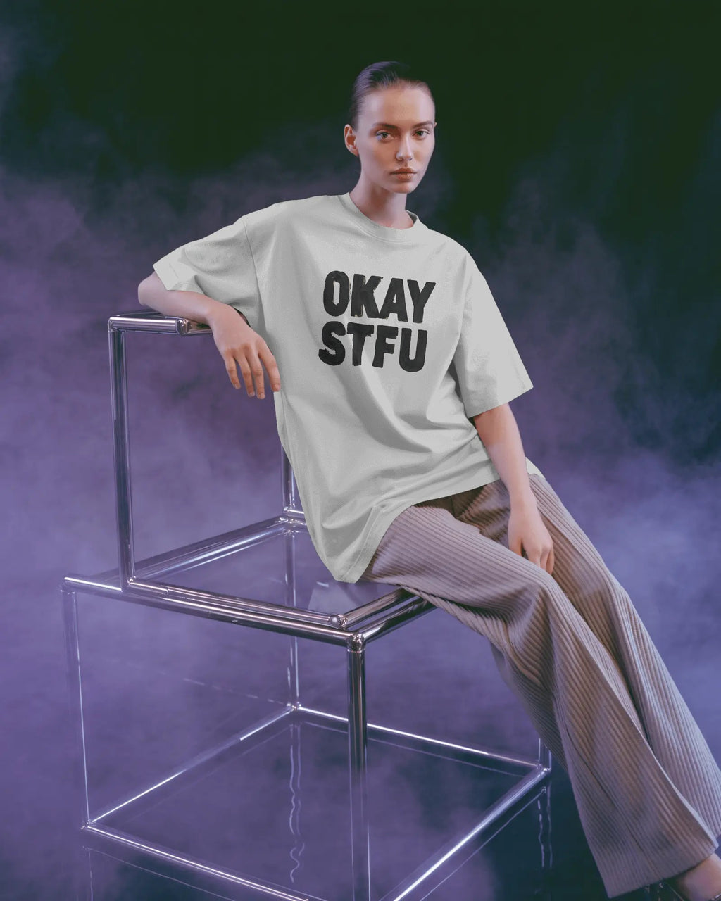 Person wearing a white Nitorious Atelier AP Dhillon concert t-shirt with 'OKAY STFU' text against a light background