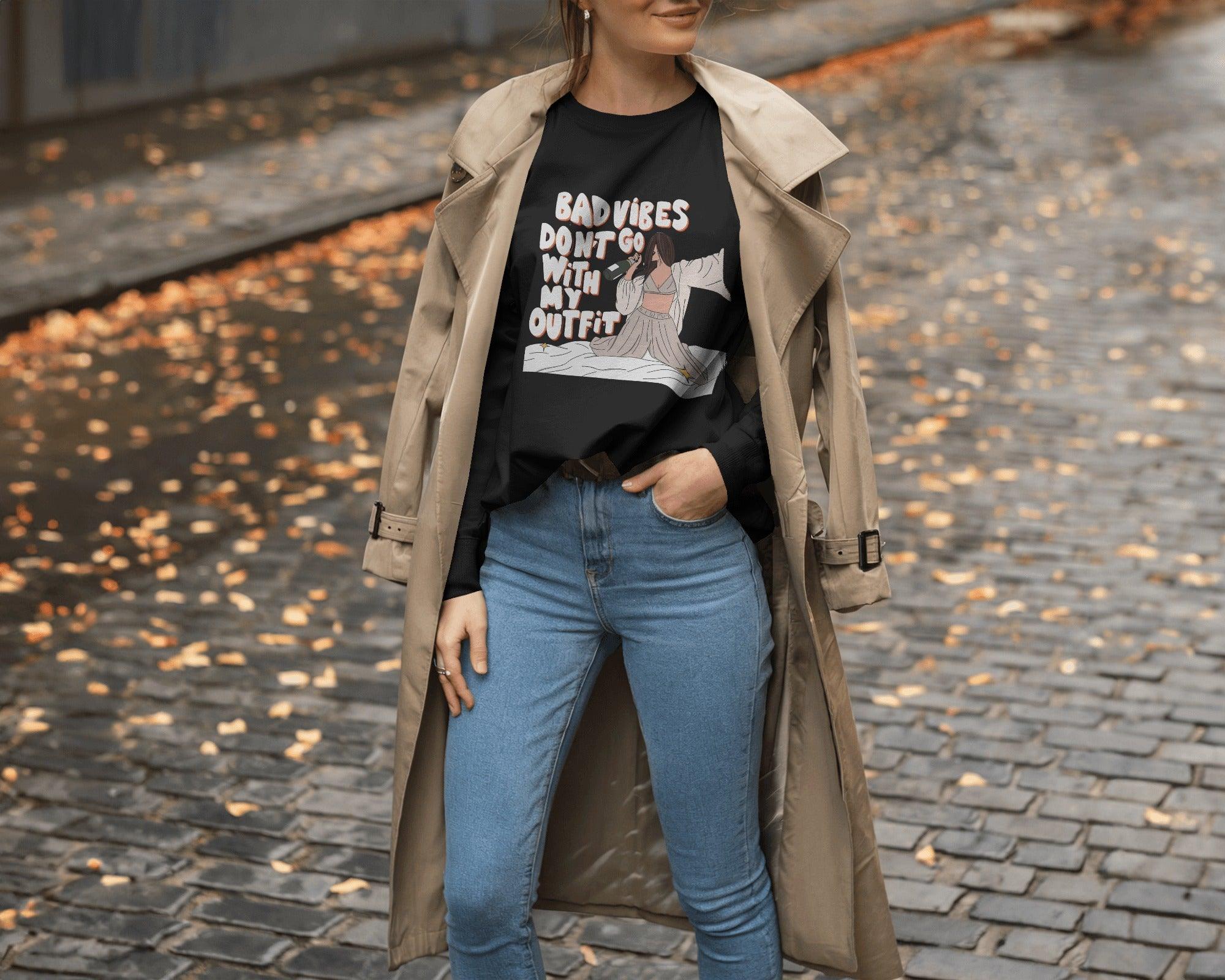 Oversized black t-shirt for women featuring the stylish quote "Bad Vibes Don’t Go with the Outfit" in bold typography. Crafted from premium cotton, this t-shirt offers a relaxed and comfortable fit. A perfect statement piece for casual and streetwear looks, adding a touch of confidence and positivity to any outfit.