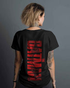 Person wearing a black t-shirt with red text on the back against a gray background
