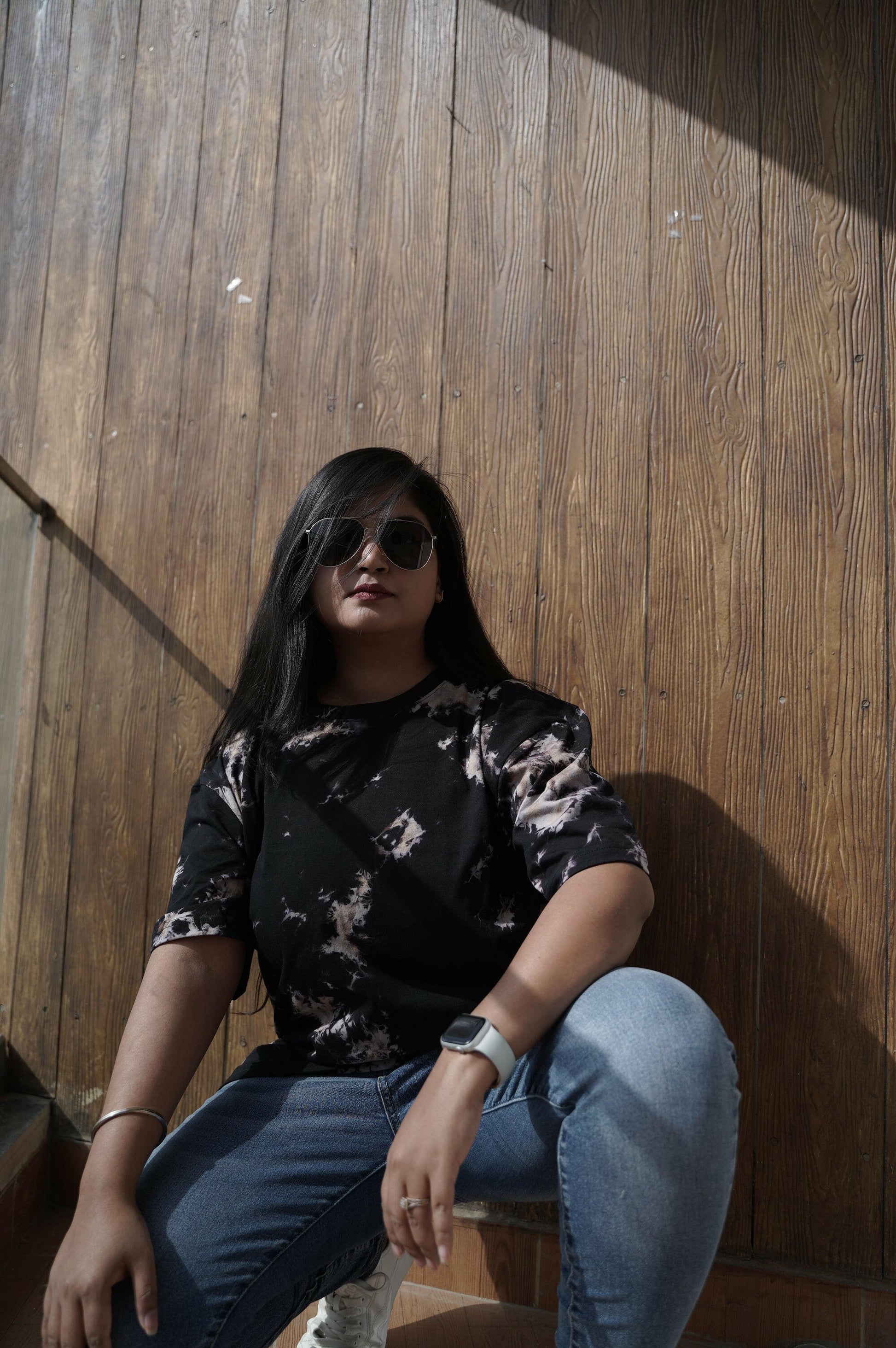 A close-up shot of a Nitorious Atelier Tie and Dye Unisex Black 100% Cotton fabric oversized T Shirt. The fabric showcases a rich black hue with intricate tie and dye patterns, crafted with high-quality cotton material.