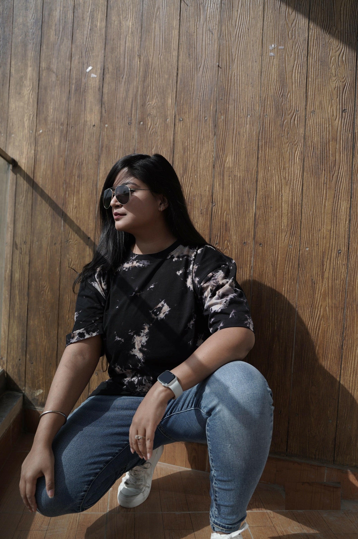 A close-up shot of a Nitorious Atelier Tie and Dye Unisex Black 100% Cotton fabric oversized T Shirt. The fabric showcases a rich black hue with intricate tie and dye patterns, crafted with high-quality cotton material.