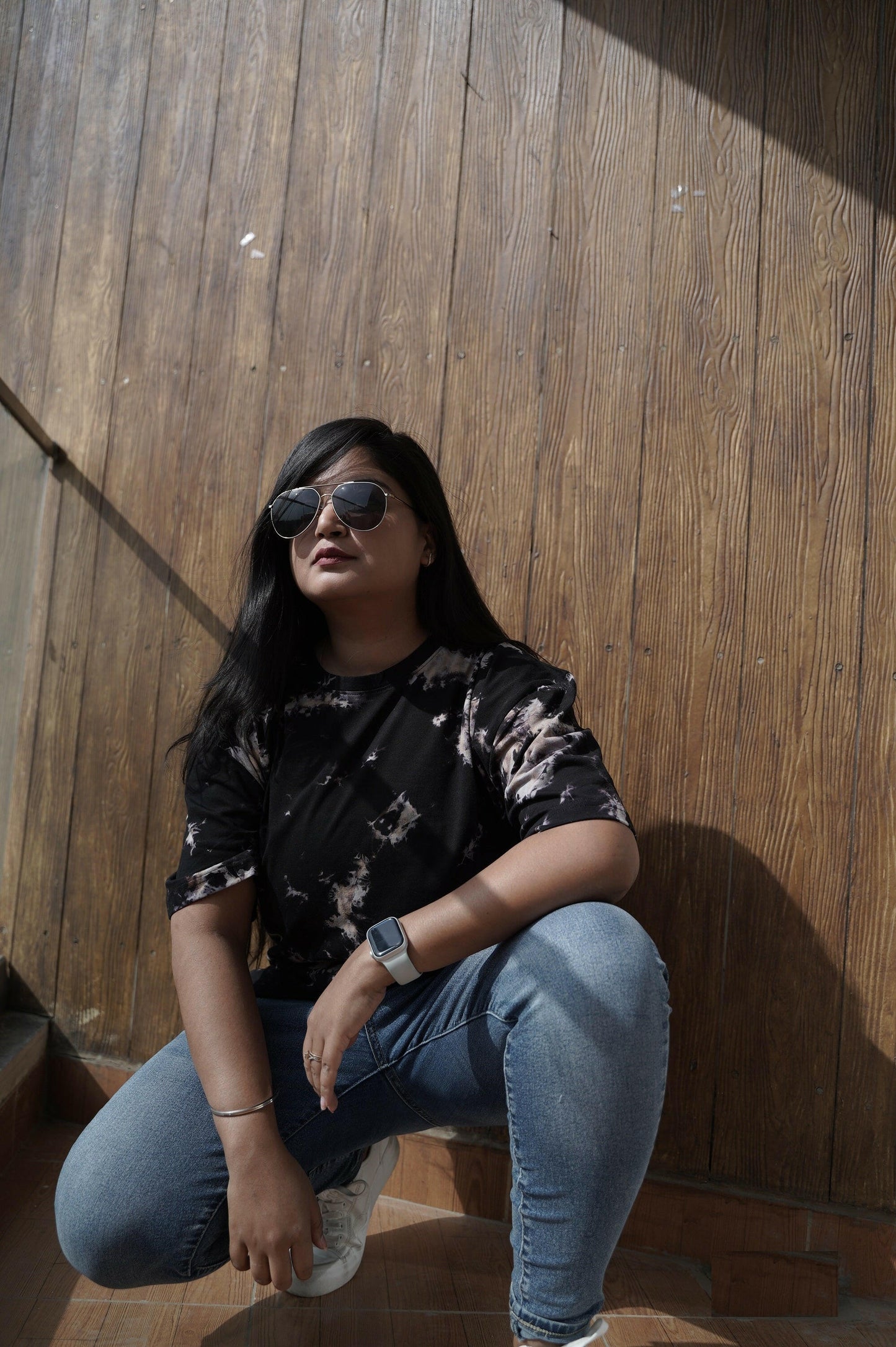 A close-up shot of a Nitorious Atelier Tie and Dye Unisex Black 100% Cotton fabric oversized T Shirt. The fabric showcases a rich black hue with intricate tie and dye patterns, crafted with high-quality cotton material.