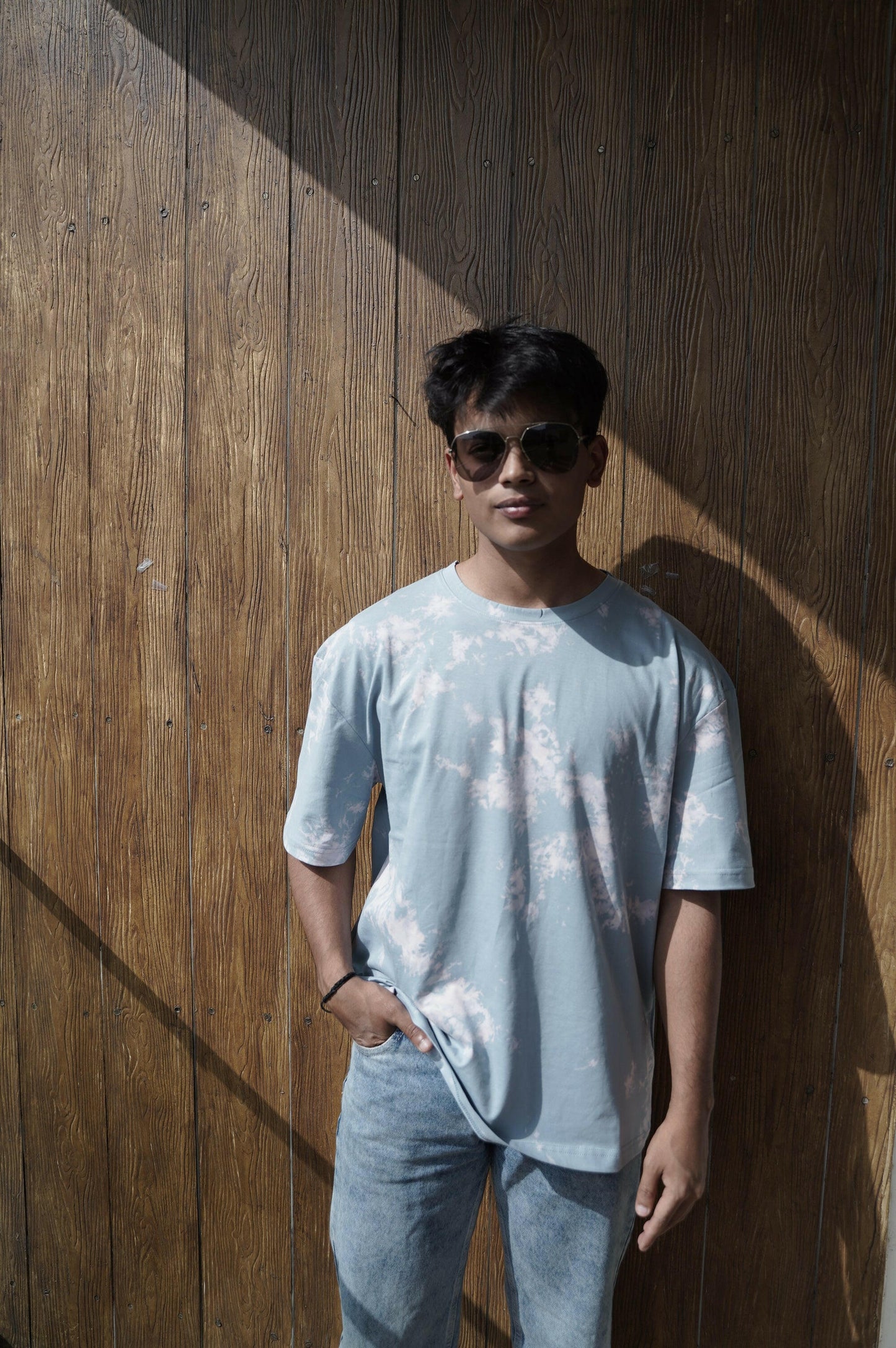 A close-up shot of a Nitorious Atelier Tie and Dye Sky Blue 100% Cotton Fabric Unisex Oversized T Shirt. The fabric showcases a rich black hue with intricate tie and dye patterns, crafted with high-quality cotton material.