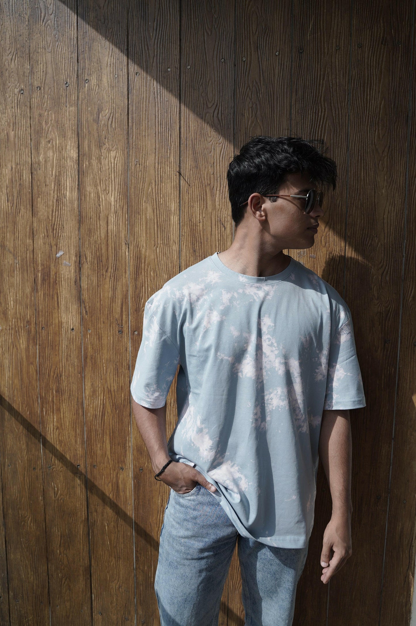 A close-up shot of a Nitorious Atelier Tie and Dye Sky Blue 100% Cotton Fabric Unisex Oversized T Shirt. The fabric showcases a rich black hue with intricate tie and dye patterns, crafted with high-quality cotton material.