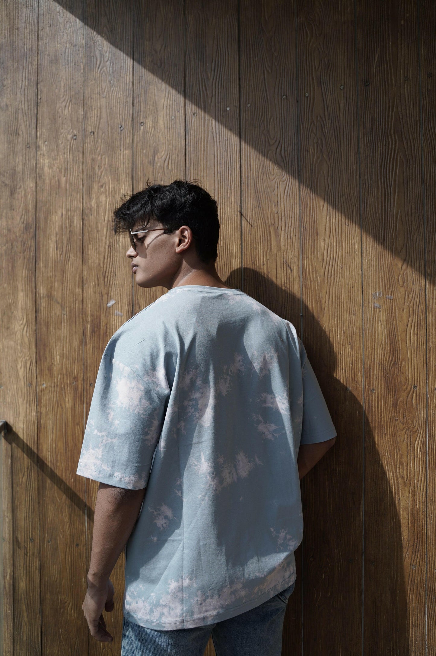 A close-up shot of a Nitorious Atelier Tie and Dye Sky Blue 100% Cotton Fabric Unisex Oversized T Shirt. The fabric showcases a rich black hue with intricate tie and dye patterns, crafted with high-quality cotton material.