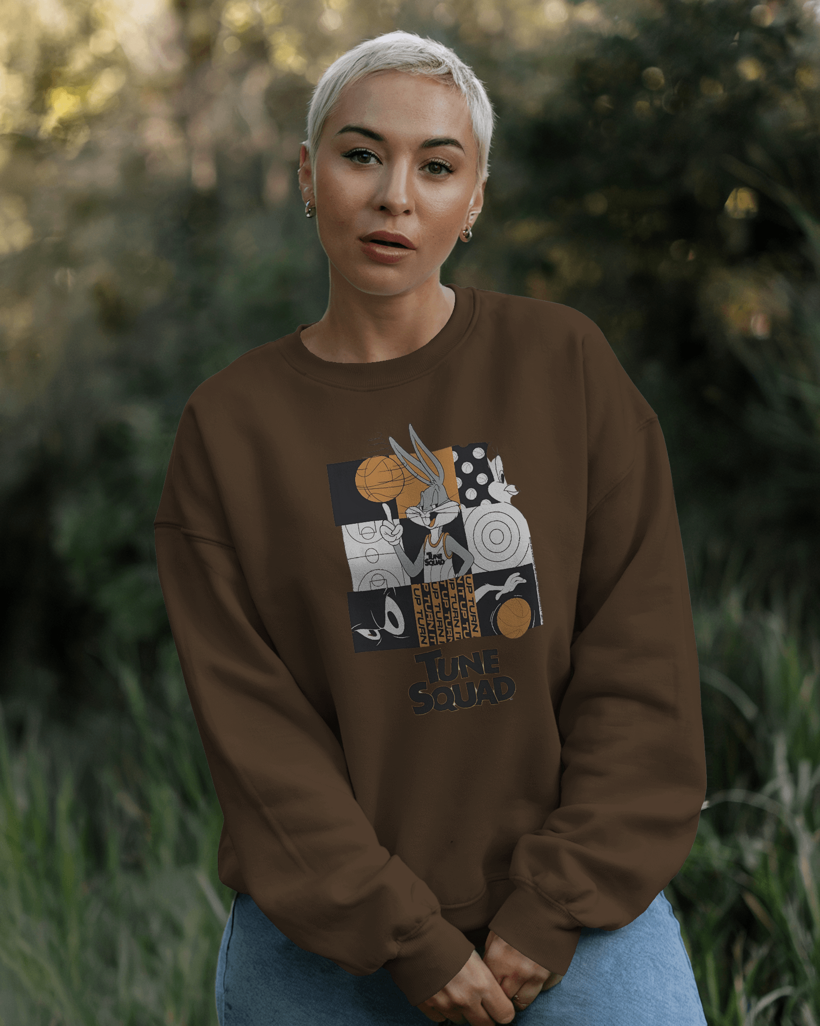 Brown Looney Tunes Sweatshirt from Nitorious Atelier featuring vibrant prints of classic Looney Tunes characters on a warm, earthy background. Made from premium fabric, this sweatshirt offers a relaxed fit and comfortable feel, adding a playful touch to casual outfits.