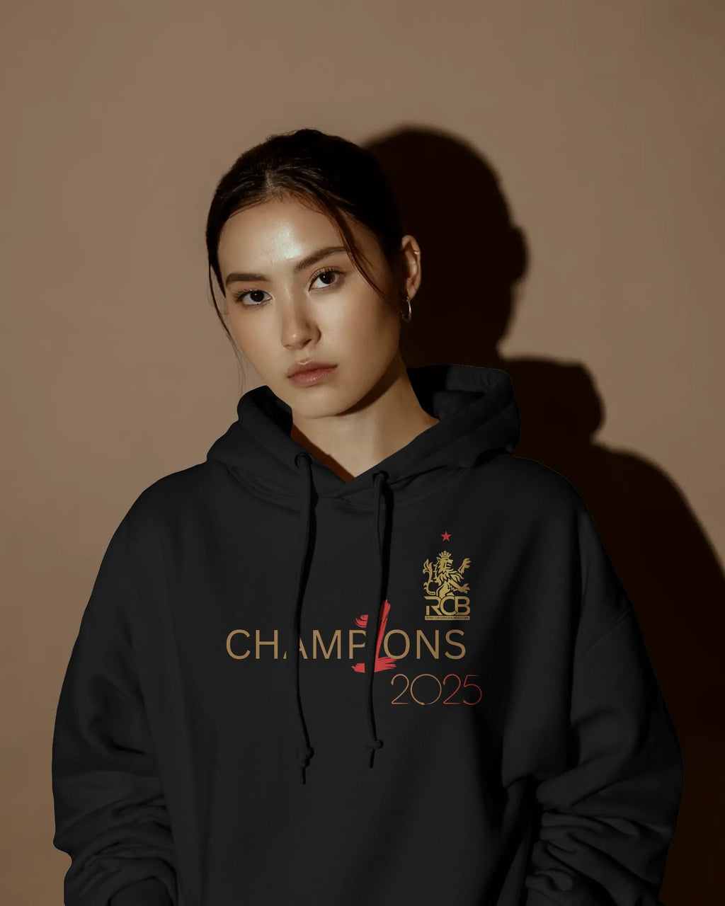 RCB Champions Luxe Hoodie in rich black, celebrating Royal Challengers Bangalore’s iconic victory. Crafted from premium cotton fleece, it features a detailed champion-themed graphic, cosy fit, and a high-quality finish for ultimate comfort and fan pride.