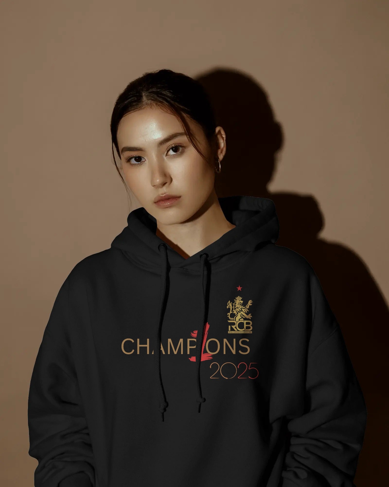 RCB Champions Luxe Hoodie in rich black, celebrating Royal Challengers Bangalore’s iconic victory. Crafted from premium cotton fleece, it features a detailed champion-themed graphic, cosy fit, and a high-quality finish for ultimate comfort and fan pride.