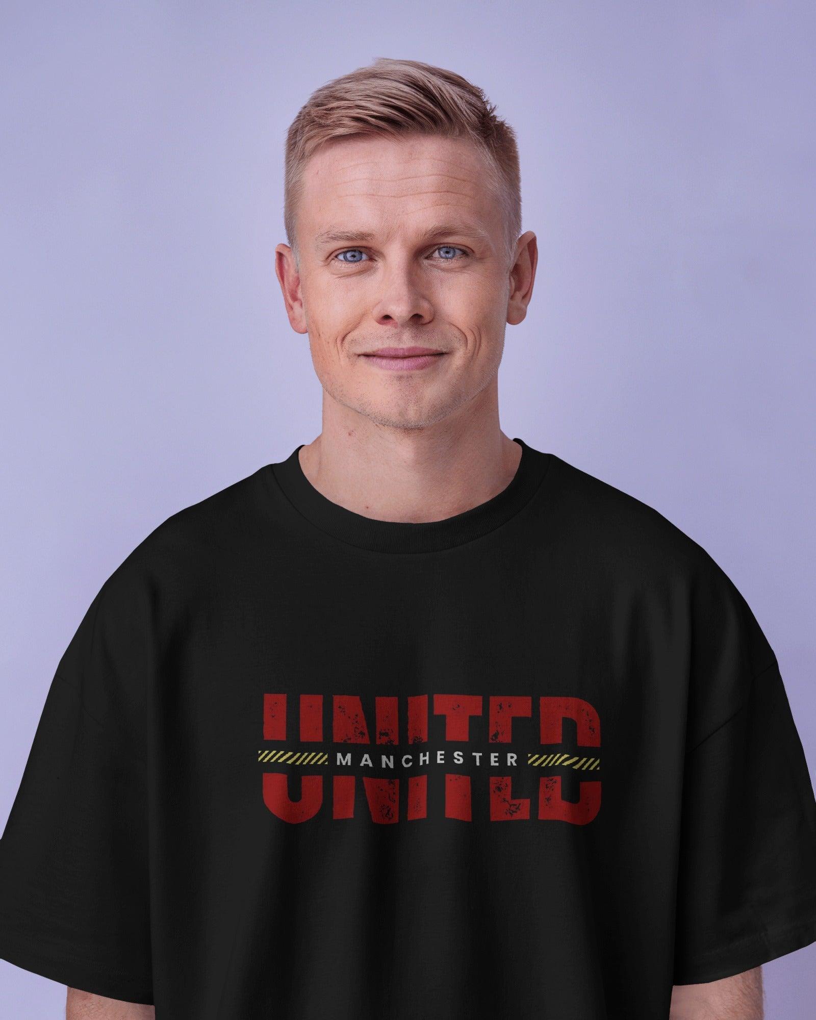 Black oversized t-shirt featuring a bold Manchester United graphic print. Made from premium cotton, this t-shirt offers a relaxed fit, soft comfort, and a stylish look for football fans.