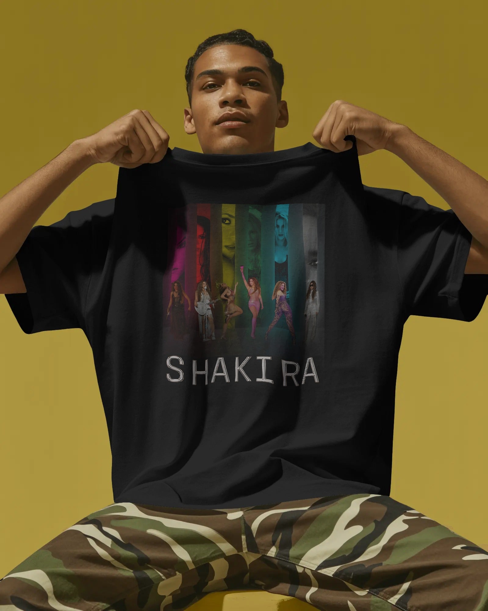 Person wearing a black t-shirt with 'Shakira' design on a yellow background