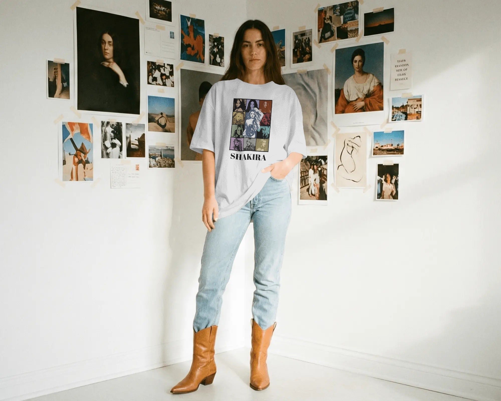 Woman wearing a 'Shakira' t-shirt in a room with artistic posters on the wall.