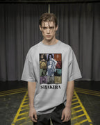 Person wearing a gray t-shirt with Shakira graphic design against a plain background