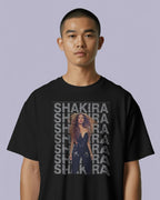 Person wearing a black t-shirt with Shakira graphic design on a light purple background