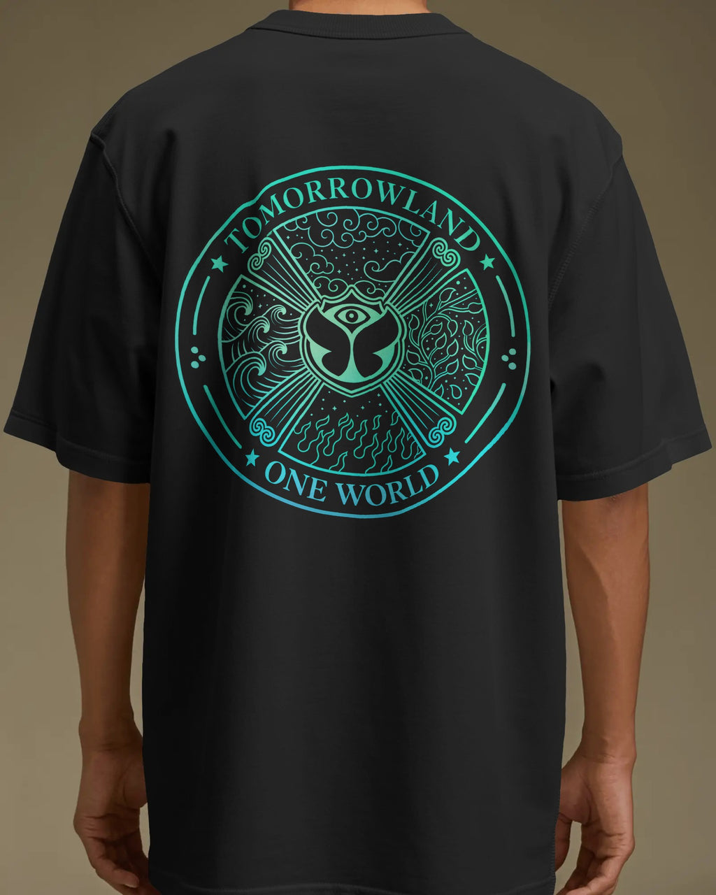 A person wearing a black short-sleeve T-shirt shown from the back, featuring a large circular teal graphic with the words 'TOMORROWLAND' and 'ONE WORLD' around an eye motif and decorative symbols.